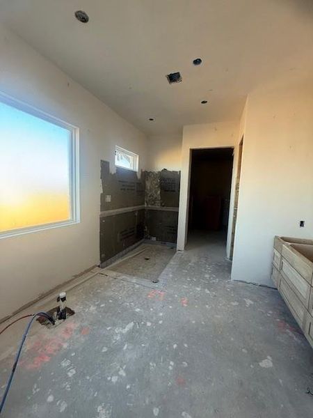 Primary bath will include upgraded tile, freestanding tub, and oversized shower. The vanity counter wall will over a large mirror with pendants hanging down from each side of the wall. Vanity will have floating cabinets, and the oversized closet will have built ins and seasonal storage.