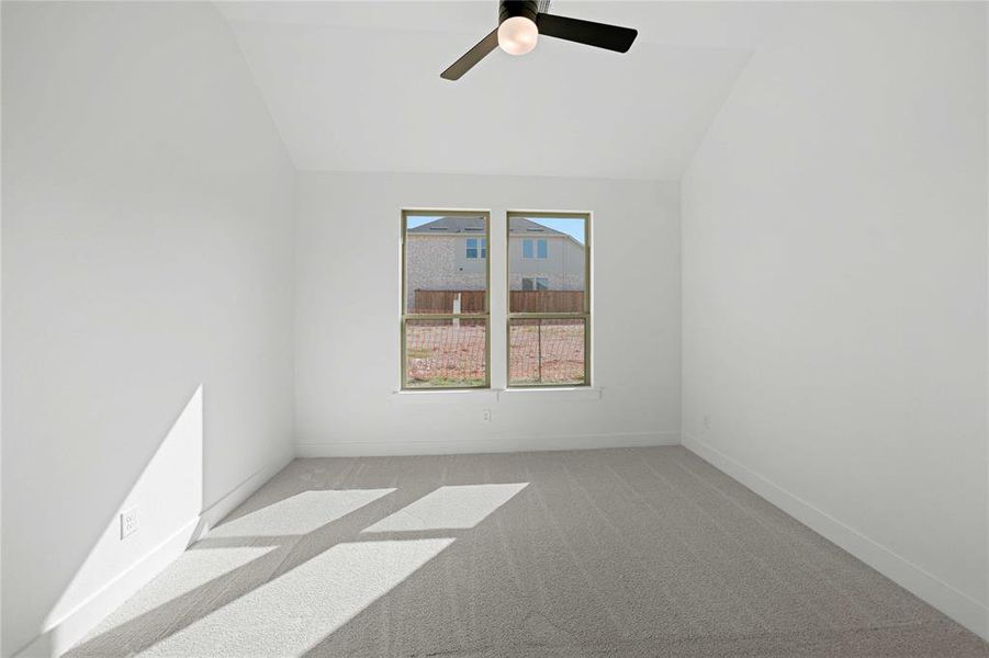 Spare room featuring light carpet, vaulted ceiling, and a ceiling fan Spare room featuring light carpet, vaulted ceiling, and a ceiling fan
