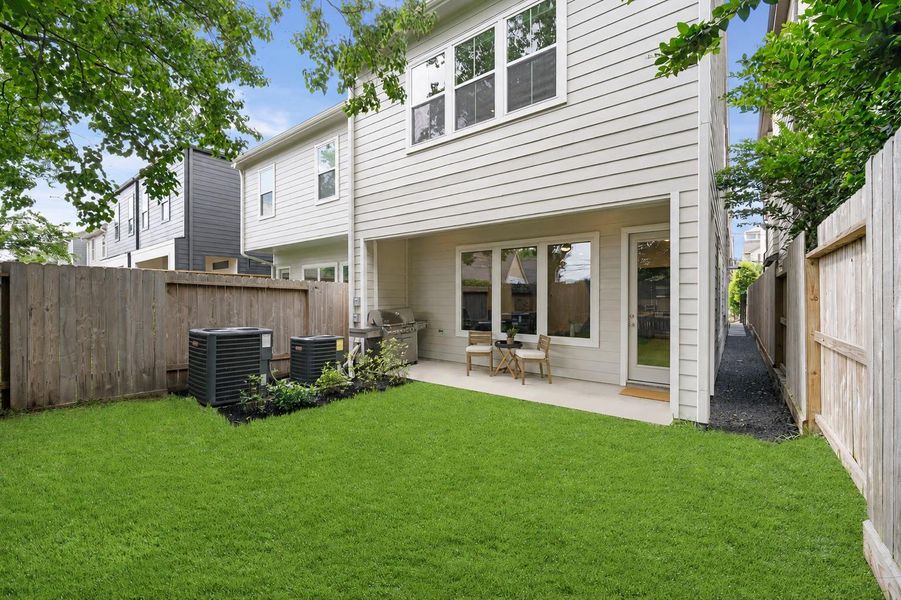 A fully fenced backyard with lush grass, mature tree shade, and a covered patio — the natural gas hookup at the patio means a grill conversion kit is all you need for a proper outdoor kitchen setup. A fully fenced backyard with lush grass, mature tree shade, and a covered patio — the natural gas hookup at the patio means a grill conversion kit is all you need for a proper outdoor kitchen setup.