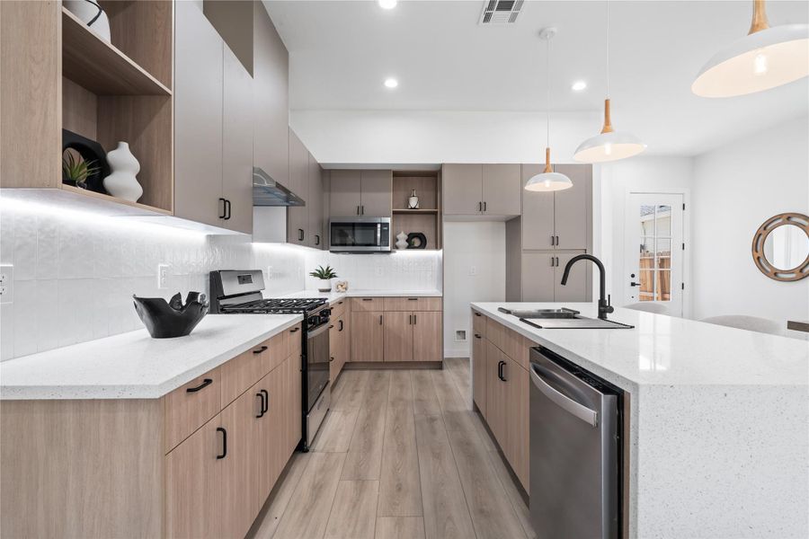 The kitchen showcases elegant two-tone cabinetry paired with warm wood accents and open shelving, creating a bright, inviting atmosphere. Thoughtfully designed, it offers abundant storage while maintaining an open, airy feel. This blend of style and functionality makes it the heart of the home, perfect for both cooking and gathering. The kitchen showcases elegant two-tone cabinetry paired with warm wood accents and open shelving, creating a bright, inviting atmosphere. Thoughtfully designed, it offers abundant storage while maintaining an open, airy feel. This blend of style and functionality makes it the heart of the home, perfect for both cooking and gathering.