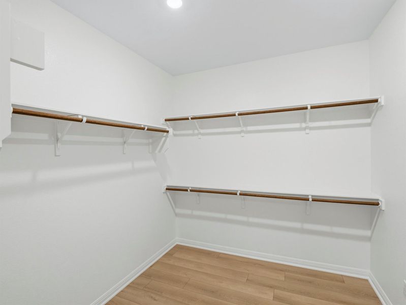 Ample shelving and hanging rods provide versatile storage in this spacious walk-in closet. Ample shelving and hanging rods provide versatile storage in this spacious walk-in closet.