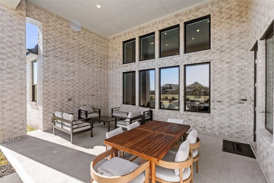 This expansive patio features soaring ceilings, a smooth concrete finish, and timeless brick surroundings that create a private, courtyard-like ambiance. This expansive patio features soaring ceilings, a smooth concrete finish, and timeless brick surroundings that create a private, courtyard-like ambiance.