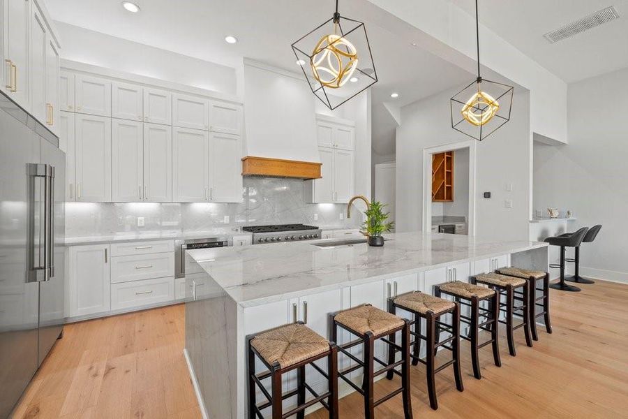 This stunning kitchen offers both style and functionality—featuring crisp white cabinetry, designer lighting, and a spacious island with seating for six. Perfect for casual meals, entertaining, or gathering with friends and family in your Canyon Lake getaway.