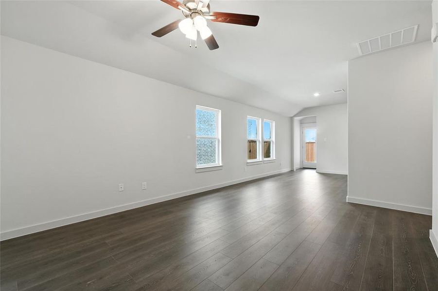 Spare room with vaulted ceiling, dark wood finished floors, and a ceiling fan Spare room with vaulted ceiling, dark wood finished floors, and a ceiling fan