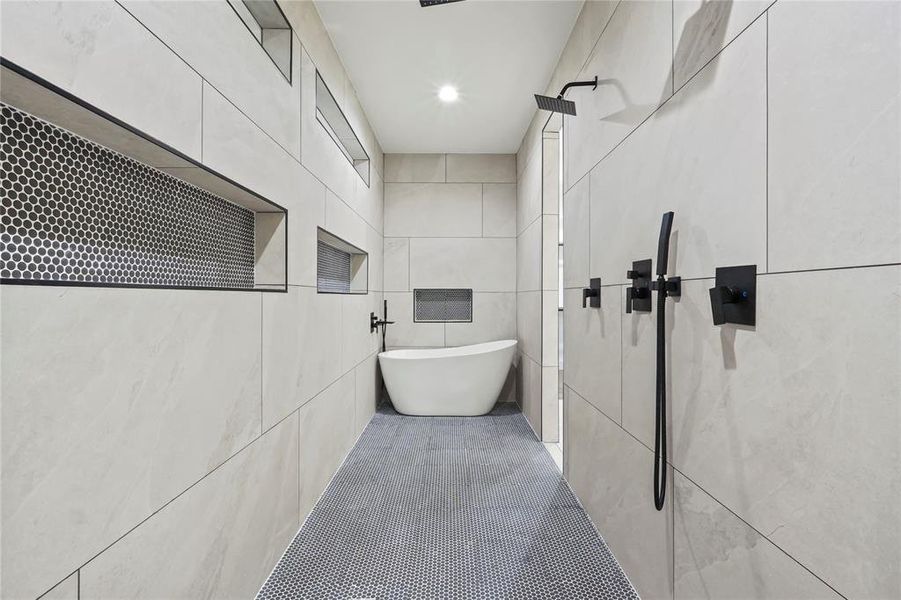 Bathroom with tile walls, walk in shower, tile patterned flooring, a freestanding tub, and recessed lighting Bathroom with tile walls, walk in shower, tile patterned flooring, a freestanding tub, and recessed lighting