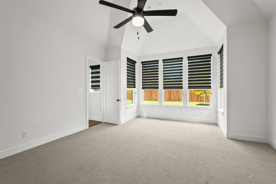Master bedroom featuring a sitting area, ceiling fan, and high vaulted ceiling Master bedroom featuring a sitting area, ceiling fan, and high vaulted ceiling