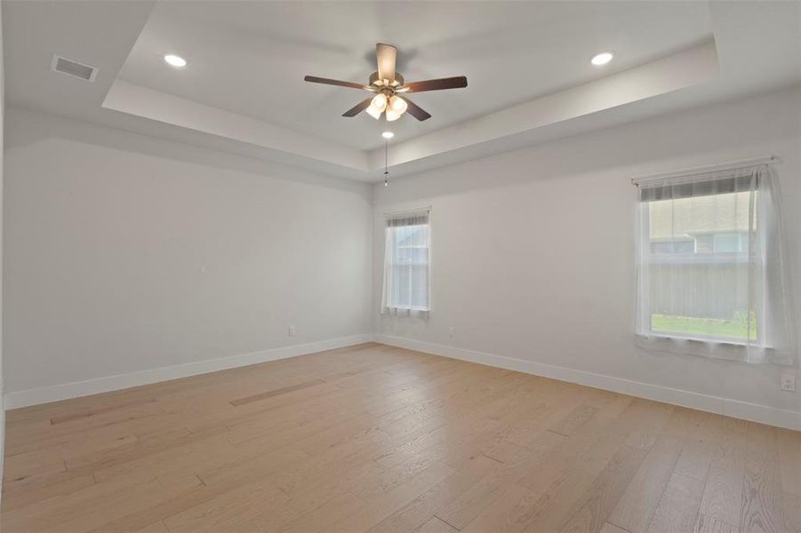 Spacious Primary Bedroom with Tray Ceiling Spacious Primary Bedroom with Tray Ceiling