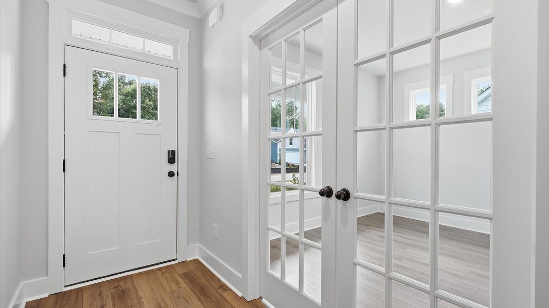 Stylish foyer with hardwood flooring and tasteful architectural detail in a superior layout
