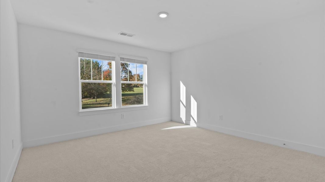 Superior comfort in this light-filled bedroom with plush carpeting and thoughtfully placed large windows