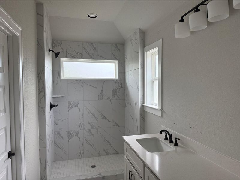 Full bathroom featuring vanity and a marble finish shower Full bathroom featuring vanity and a marble finish shower