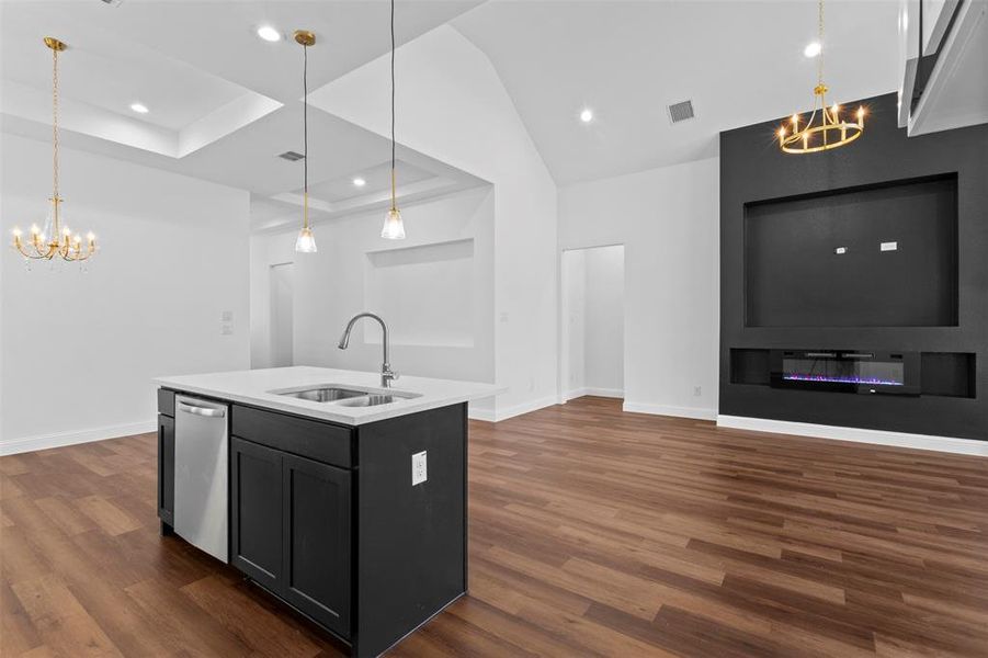 Kitchen featuring a chandelier, lofted ceiling, light countertops, dark wood-style floors, and recessed lighting Kitchen featuring a chandelier, lofted ceiling, light countertops, dark wood-style floors, and recessed lighting