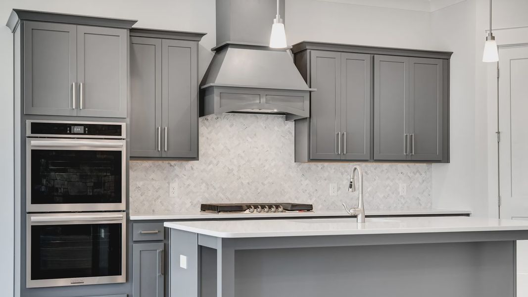 Modern kitchen with island, gray cabinets, and tile backsplash