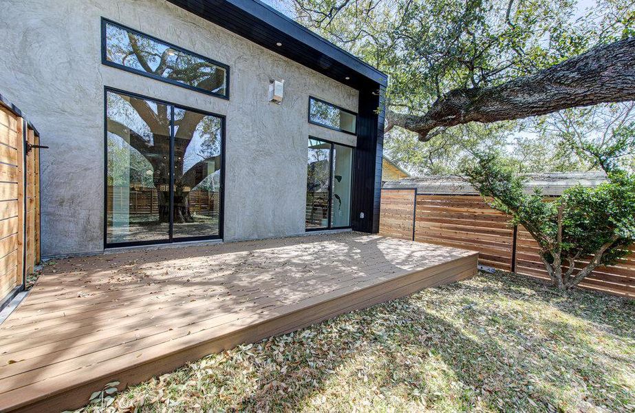 Property entrance featuring a deck, fence, and stucco siding