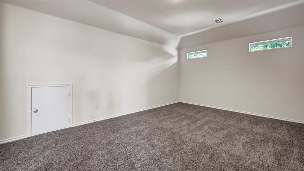 Spacious room featuring neutral carpeting and white wall finishes