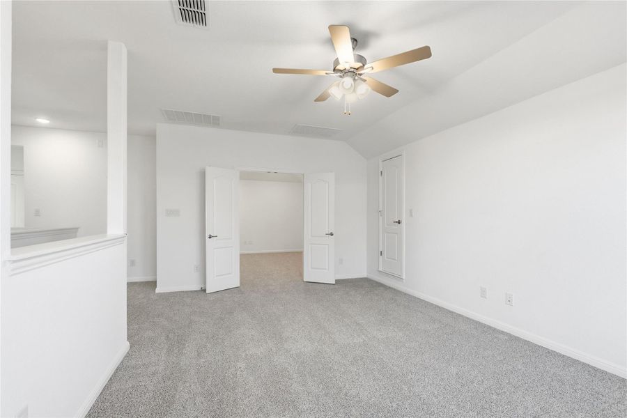 Unfurnished bedroom with carpet floors, ceiling fan, and vaulted ceiling