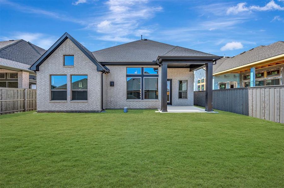 Rear view of house with a patio area, a fenced backyard, and brick siding