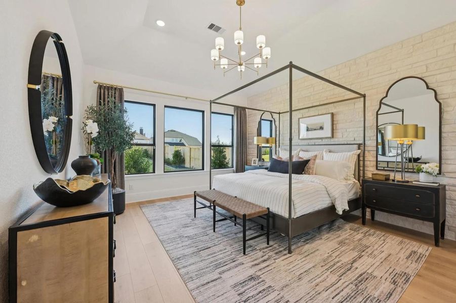 Naturally illuminated bedroom with expansive windows and vaulted ceilings creating an airy ambiance. Naturally illuminated bedroom with expansive windows and vaulted ceilings creating an airy ambiance.