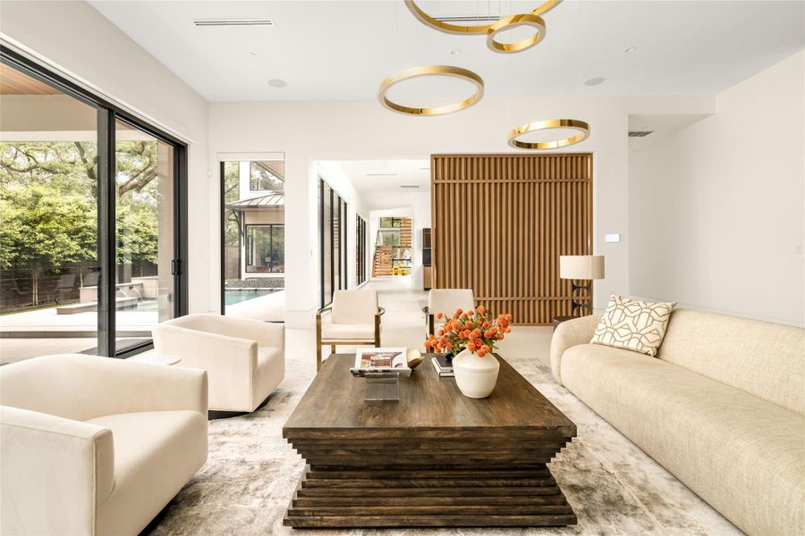 Seamless visual flow from the living room to the front staircase highlights the home’s clean lines and intentional layout.