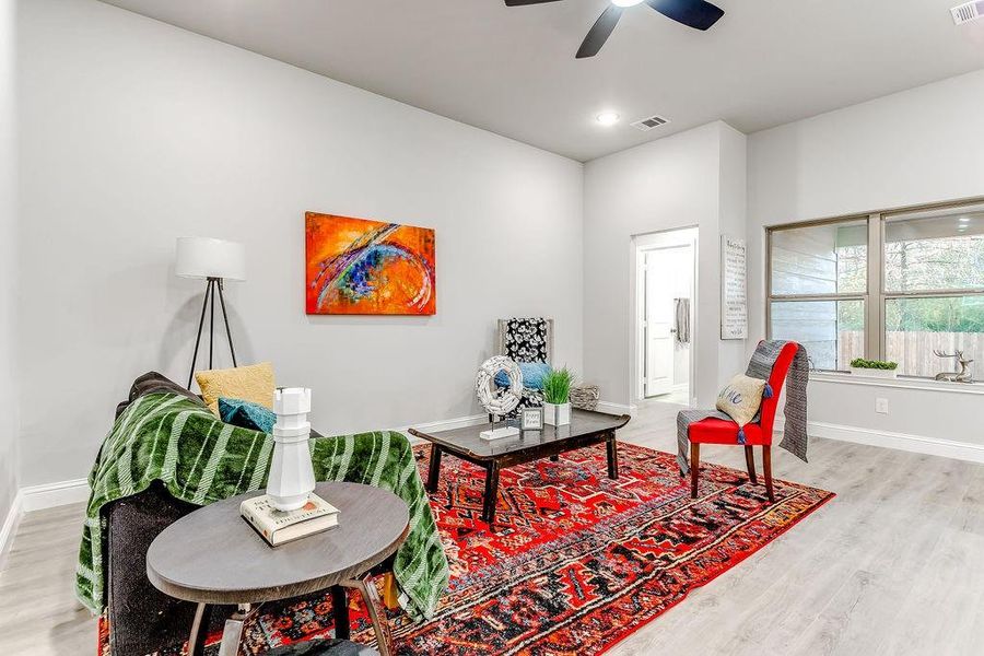 Sitting room with ceiling fan and light wood-type flooring