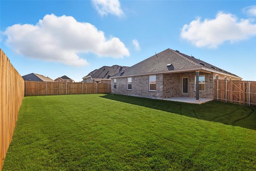 Rear view of property with brick siding, a fenced backyard, a patio, and a shingled roof Rear view of property with brick siding, a fenced backyard, a patio, and a shingled roof