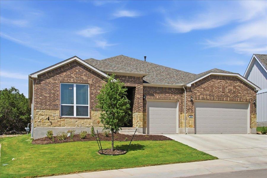 Brick and stone accents adorn this charming residence, boasting a tidy lawn and convenient attached garages. Brick and stone accents adorn this charming residence, boasting a tidy lawn and convenient attached garages.