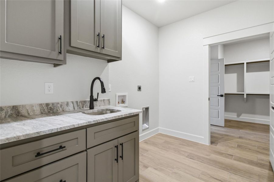 Functional laundry space includes a built-in sink and ample cabinetry. Functional laundry space includes a built-in sink and ample cabinetry.