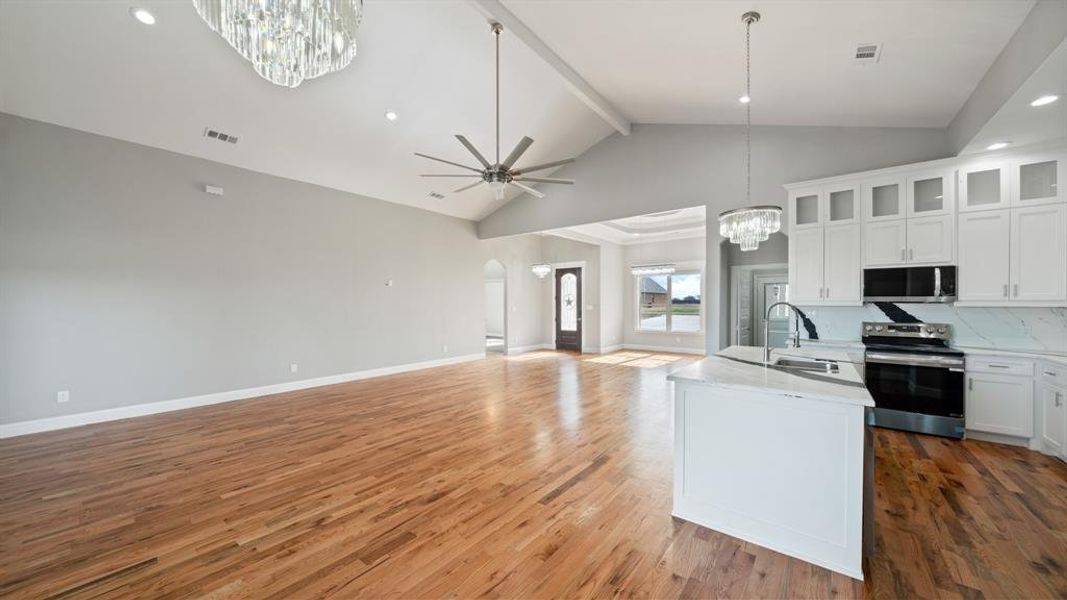 Kitchen with light wood-style flooring, stainless steel appliances, a sink, visible vents, and open floor plan