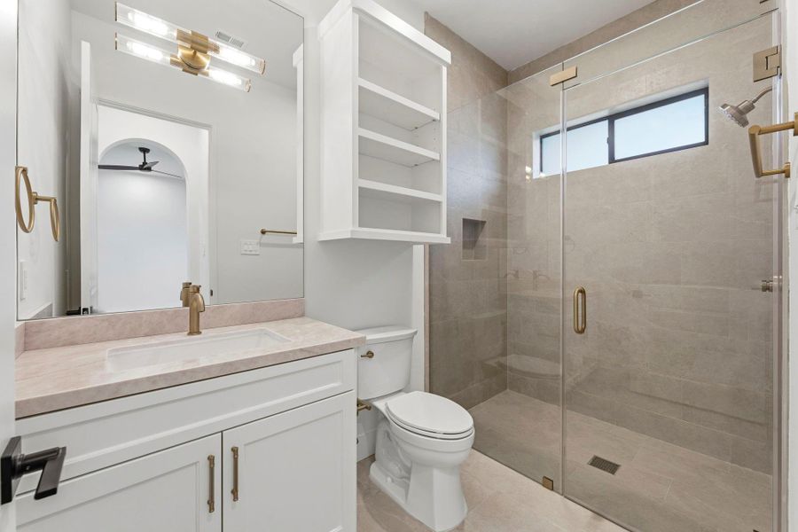 Bathroom #3 (Attached to Bedroom #2). Features a CUSTOM shower, TRANSOM window, gold hardware, and MODERN light fixture!