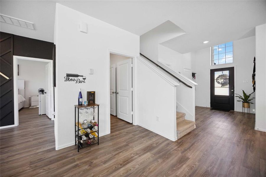 Open airy foyer breezeway leading to family room with a view of the laundry area