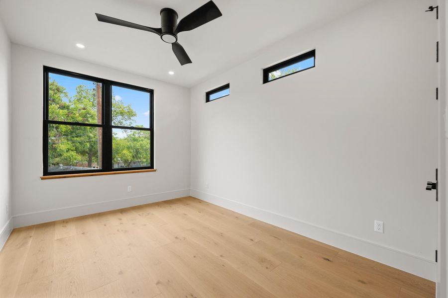 Clean lines and warm hardwood flooring define this contemporary, light-filled bedroom space.