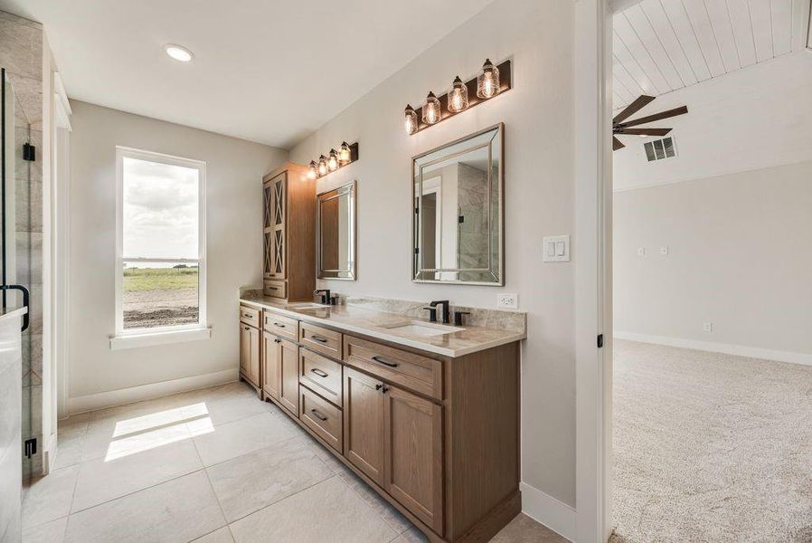 Full bath with double vanity, a ceiling fan, and a shower stall