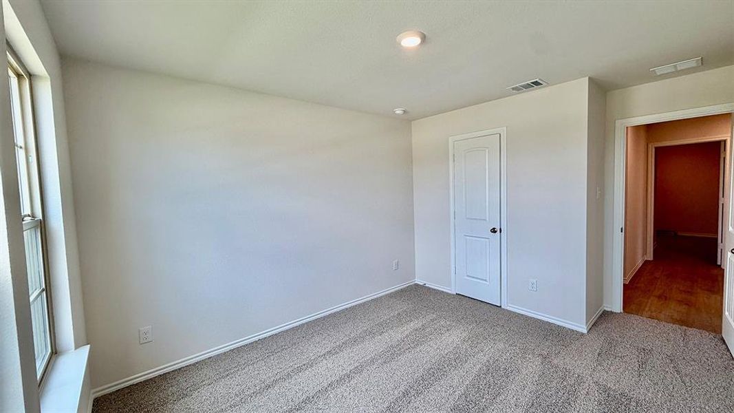 Carpeted room featuring a white interior door, a single window, and recessed lighting