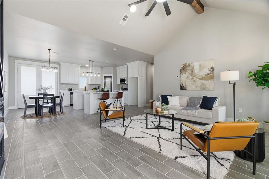 Living room with wood finish floors, high vaulted ceiling, beam ceiling, a chandelier, and a ceiling fan