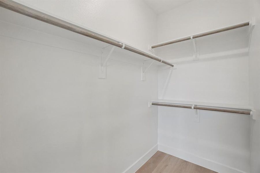 Spacious closet featuring light wood-style flooring