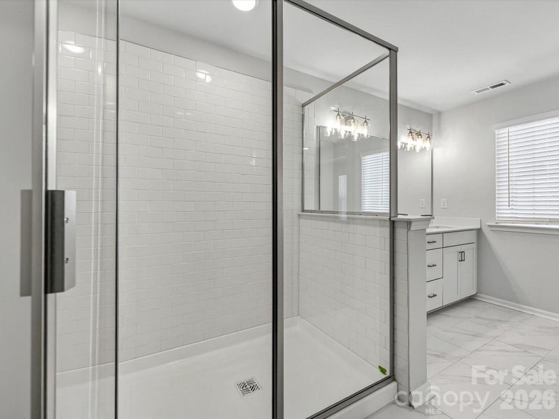 ual owners' vanity with soft close doors and drawers, quartz countertops, tiles shower with bench. 12x14 tiled floors