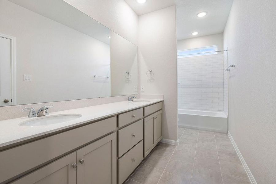 Bathroom featuring double vanity, washtub / shower combination, light tile patterned floors, and recessed lighting