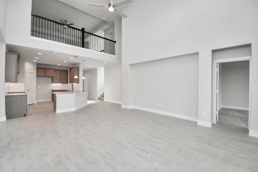 Relax and unwind in this inviting family room, illuminated by abundant natural light streaming in through tall windows, complemented by high ceilings and stunning flooring. Stay comfortable year-round with the gentle breeze from the ceiling fan, creating the perfect atmosphere for family gatherings. Sample photo of completed home with similar floor plan. Actual colors and selections may vary. Relax and unwind in this inviting family room, illuminated by abundant natural light streaming in through tall windows, complemented by high ceilings and stunning flooring. Stay comfortable year-round with the gentle breeze from the ceiling fan, creating the perfect atmosphere for family gatherings. Sample photo of completed home with similar floor plan. Actual colors and selections may vary.