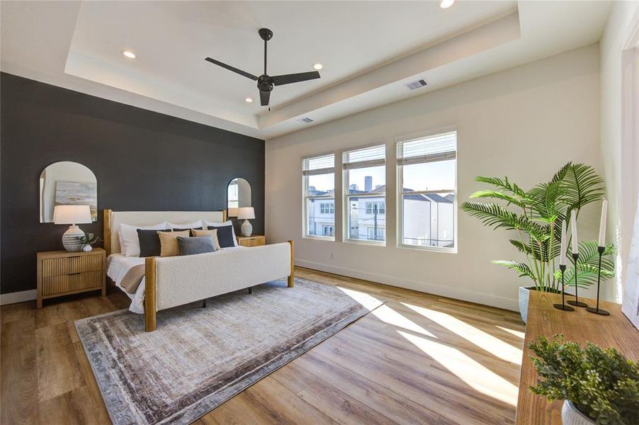 This oversized primary bedroom on the 3rd floor features a tray ceiling and tons of natural light. Includes two walk-in closets: one in the bedroom and the other in the bathroom.