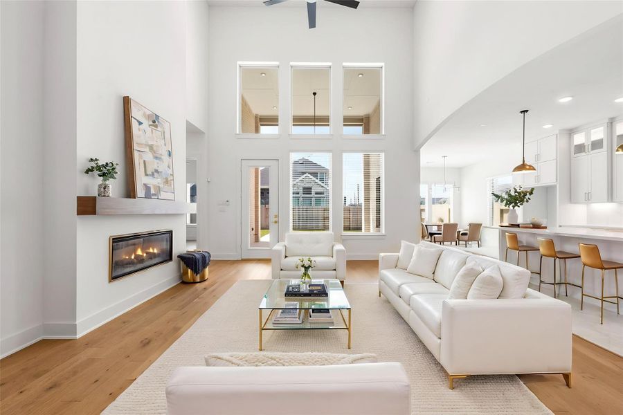 This light-filled open-concept living space exudes elegance with soaring ceilings, a custom fireplace, and upgraded engineered wood flooring that seamlessly connects to the gourmet kitchen for sophisticated entertaining. Virtually staged.