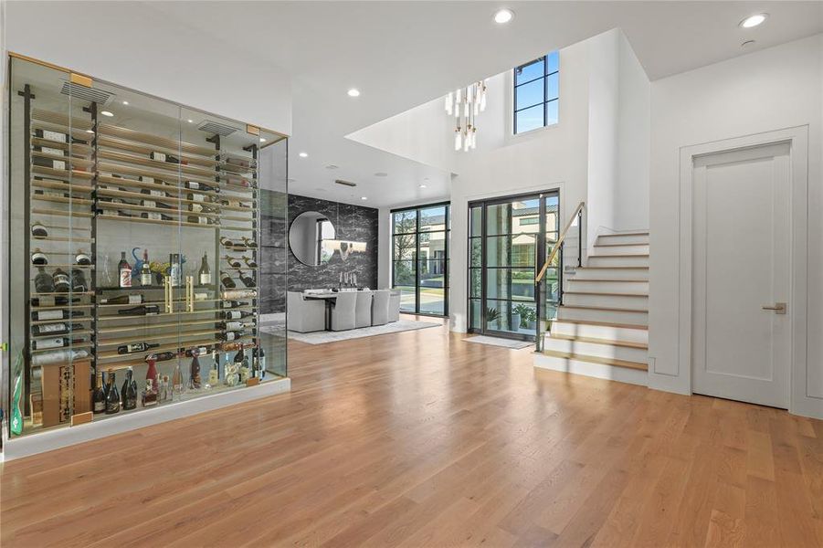 Entrance foyer with healthy amount of natural light, recessed lighting, wood finished floors, stairs, and a towering ceiling Entrance foyer with healthy amount of natural light, recessed lighting, wood finished floors, stairs, and a towering ceiling