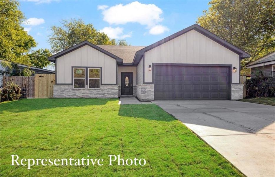 View of front of home featuring a front yard and a garage