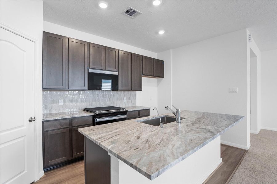 The extended breakfast bar provides additional seating—perfect for a quick meal—while keeping you connected to conversations in both the kitchen and dining area.