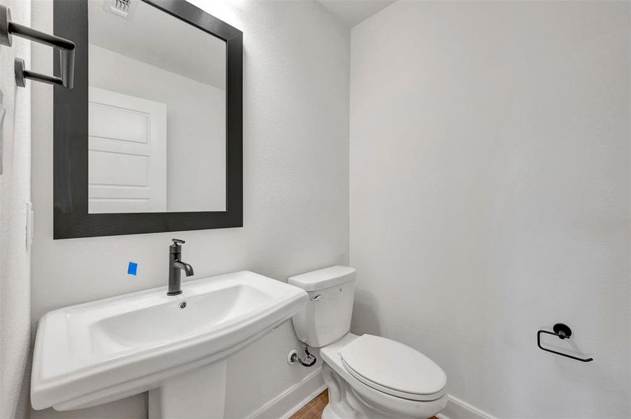 Pedestal sink with matte black faucet and framed mirror Pedestal sink with matte black faucet and framed mirror