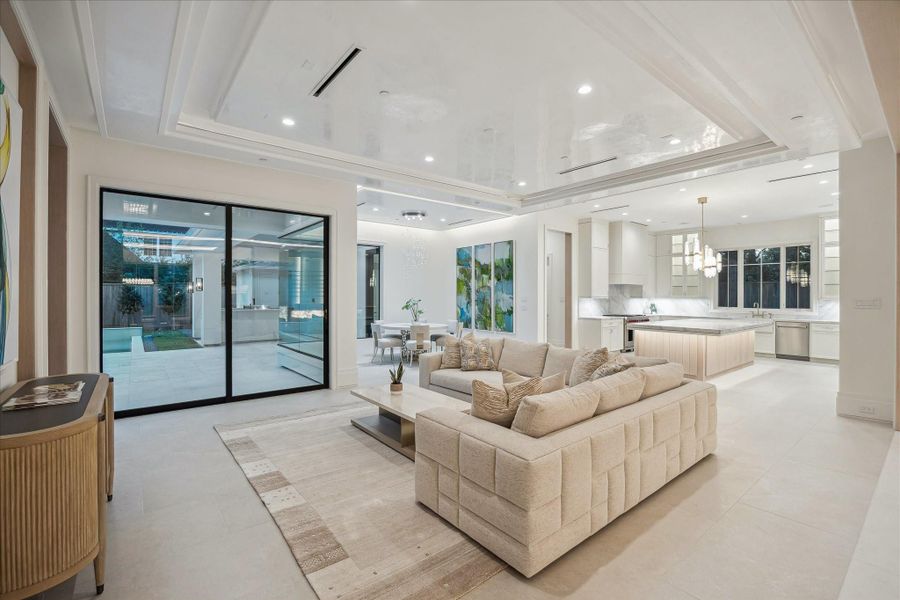 Stunning family room is anchored by a Venetian plaster ceiling that adds a soft, luminous sheen throughout the space. Family room flows effortlessly into the dining area and designer kitchen, creating a bright and sophisticated - informal gathering hub.