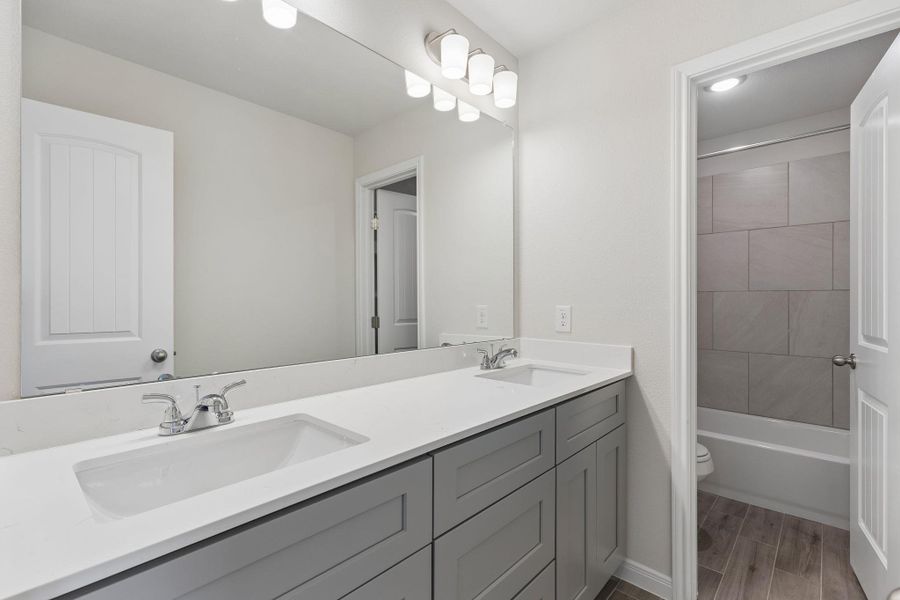 Modern vanity layout with adjacent tub access.