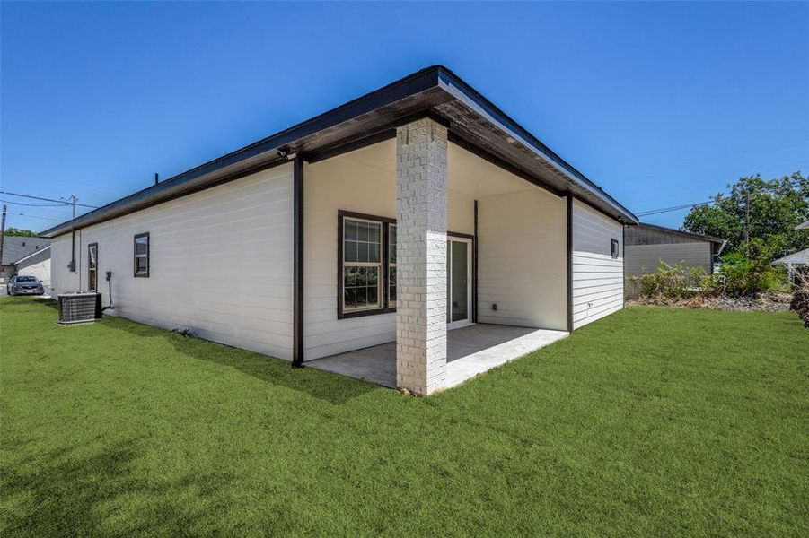 Back of house with a lawn, a patio area, and central air condition unit