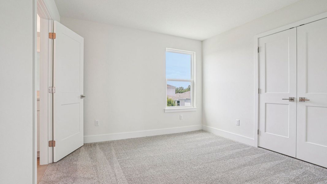 Spacious carpeted bedroom in the Plumeria plan at Lakeside at Satilla by DRB Homes. Spacious carpeted bedroom in the Plumeria plan at Lakeside at Satilla by DRB Homes.