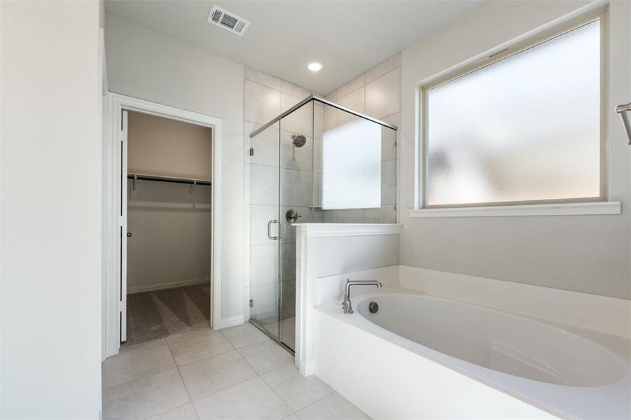 Full bathroom featuring a garden tub, a walk in closet, a stall shower, light tile patterned floors, and recessed lighting