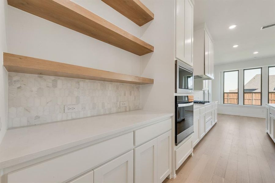 Kitchen featuring white cabinets, open shelves, tasteful backsplash, recessed lighting, and light wood finished floors Kitchen featuring white cabinets, open shelves, tasteful backsplash, recessed lighting, and light wood finished floors