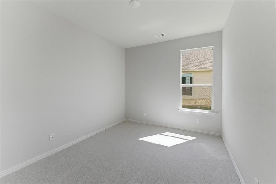 Empty room featuring light colored carpet and baseboards